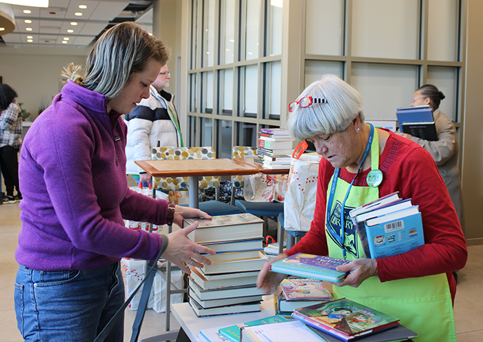 A member of the Friends of the Library checking out a patron's books at our library booksale