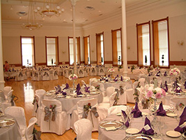 A large ballroom that has round tables with formal tablecloths and decor