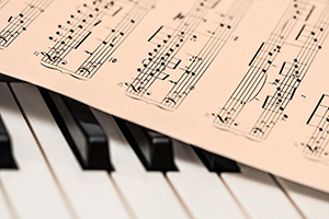 A piece of sheet music sitting on top of the keys of a piano