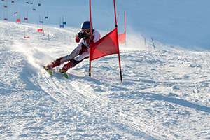 A person skiing down a slope weaving around flags
