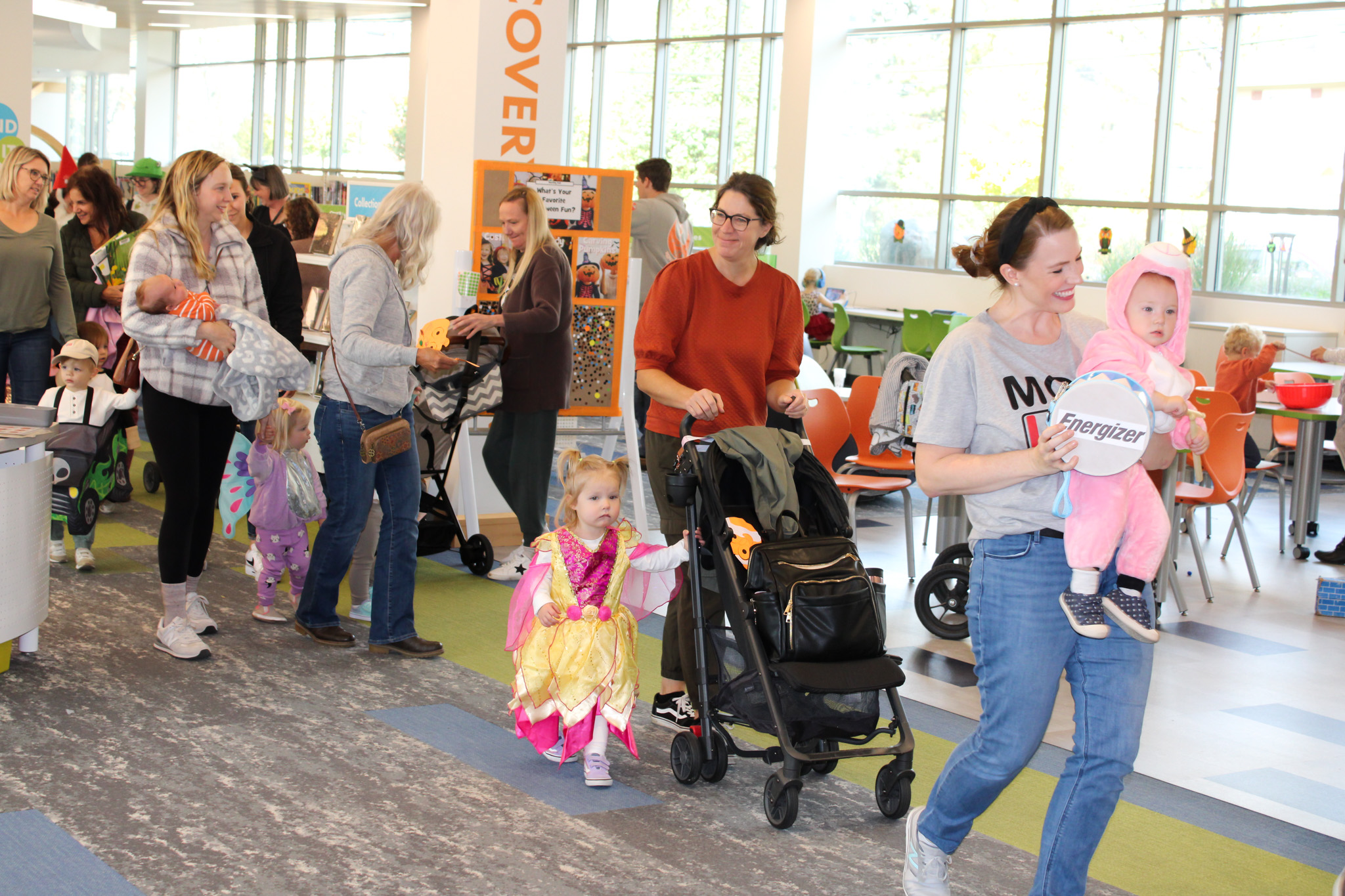 Parents and children walk in costume through Kids Landing at the Geneva Public Library as part of our costume parade