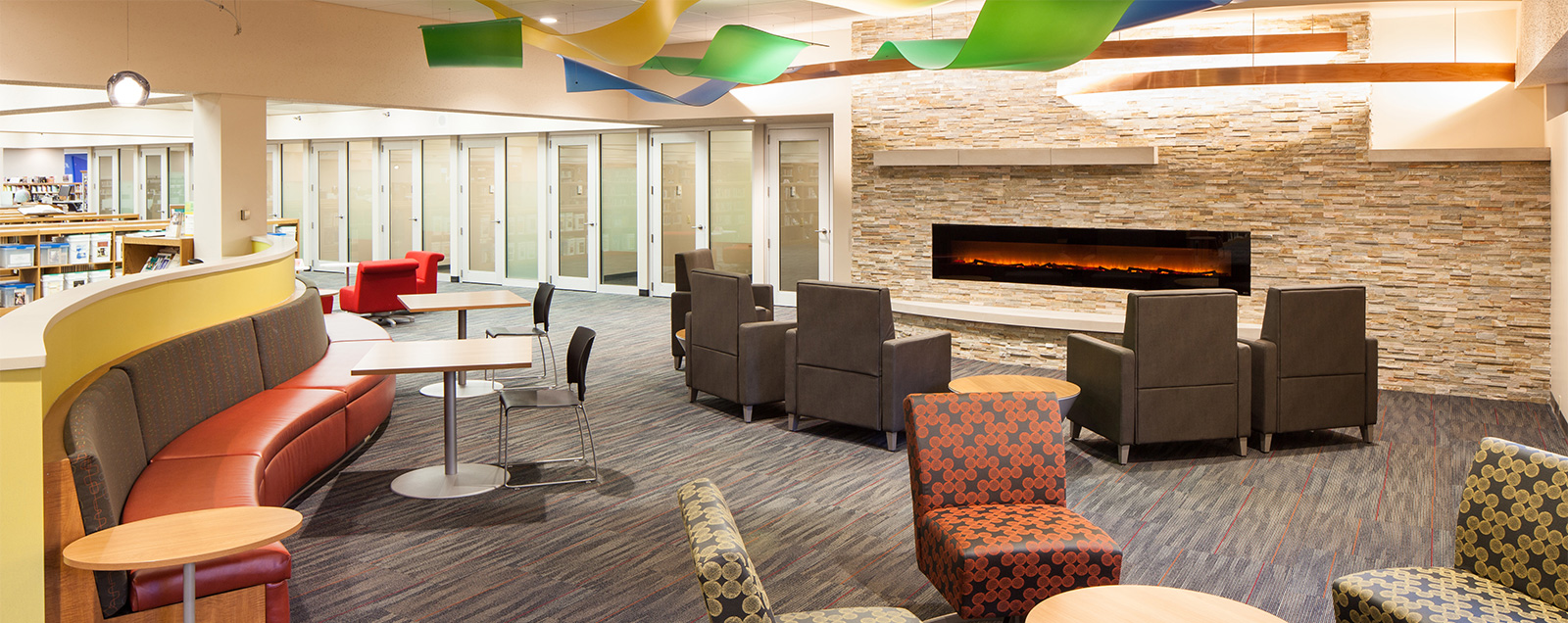 Cozy library reading and sitting area with a fireplace.