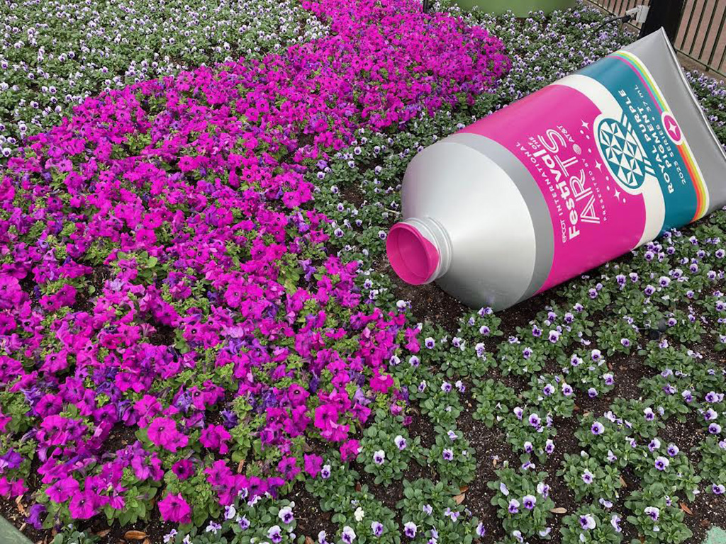 Purple paint tub laying in flower bed