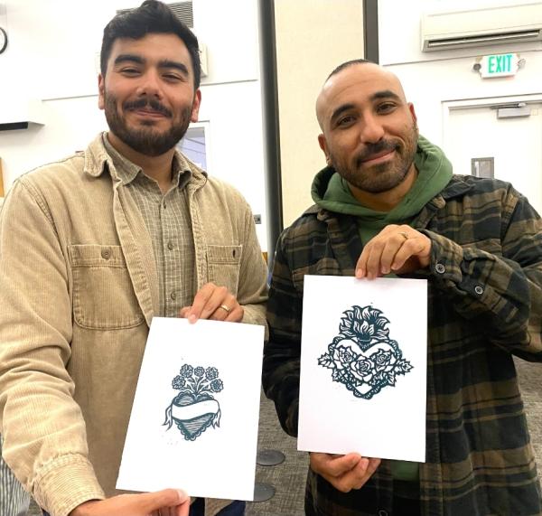 two people holding Dia de los Muertos art prints